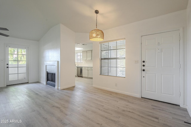 6885 E Cochise Rd Unit 219, Paradise Valley, AZ 85253 - entrance foyer featuring light wood finished floors, a fireplace, a ceiling fan, and vaulted ceiling