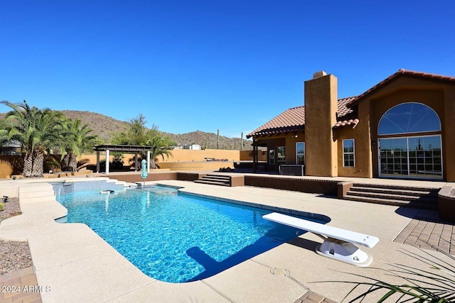 view of swimming pool with a mountain view, a diving board, a patio area, and a pergola