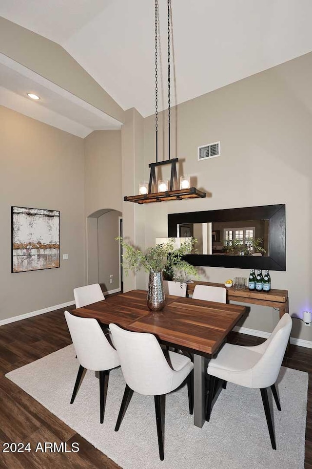 dining room featuring dark wood-type flooring and vaulted ceiling