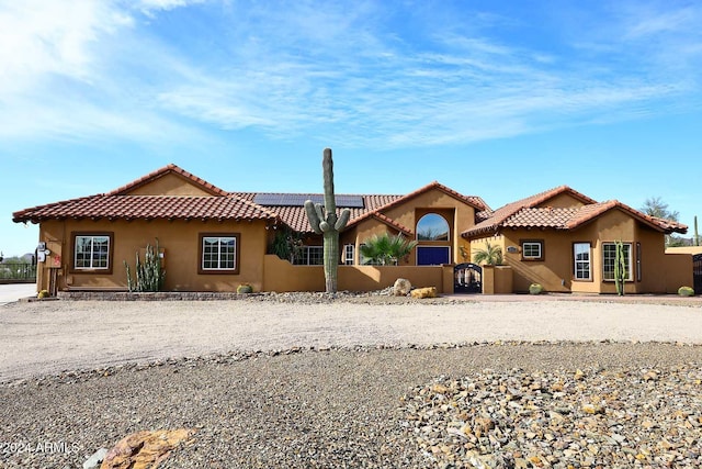 mediterranean / spanish-style house with solar panels