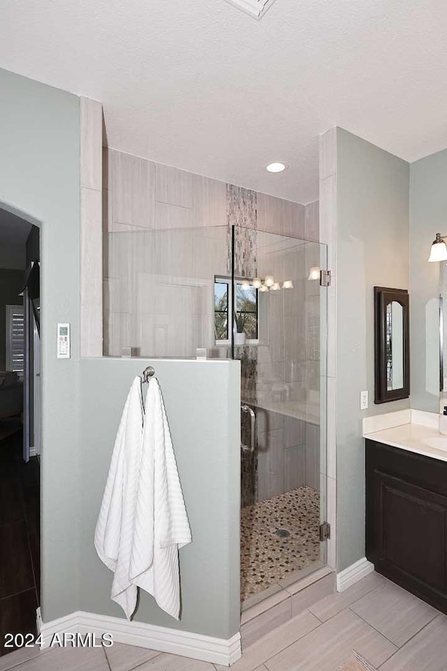 bathroom with vanity and a shower with door