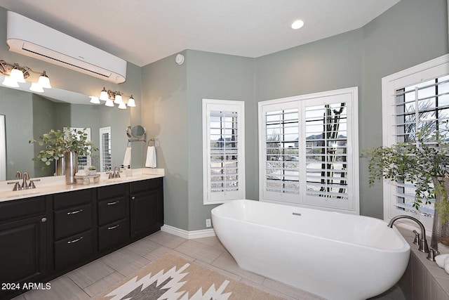 bathroom featuring a washtub, vanity, plenty of natural light, and a wall mounted AC