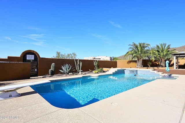 view of swimming pool with a patio area and a diving board