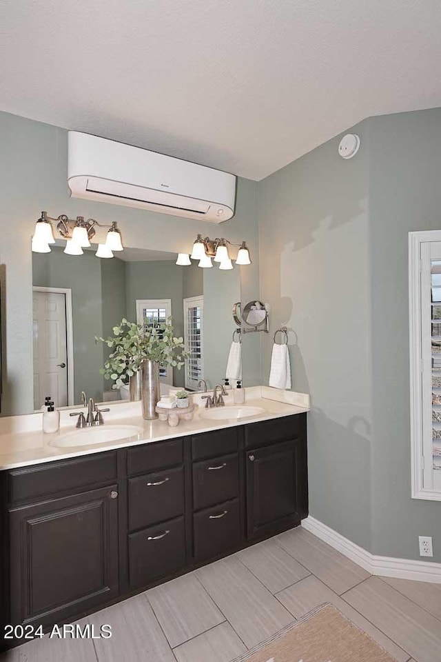 bathroom with a wall mounted air conditioner, vanity, and a healthy amount of sunlight