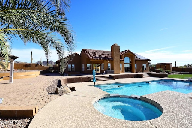 view of pool with an in ground hot tub and a patio