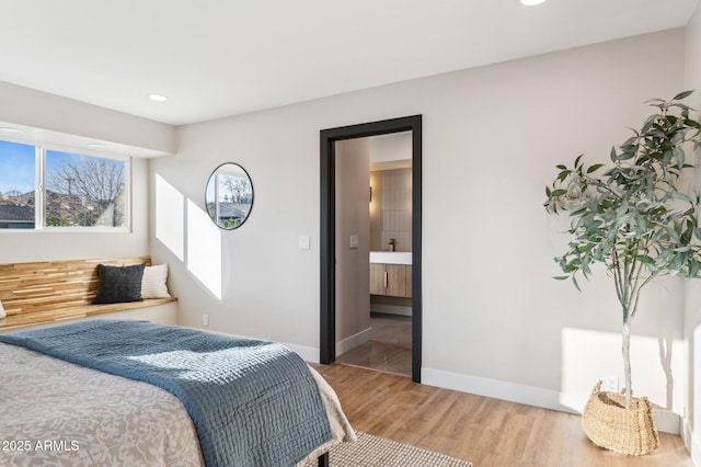 bedroom featuring hardwood / wood-style floors and connected bathroom