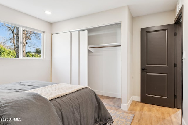 bedroom featuring light wood-type flooring and a closet