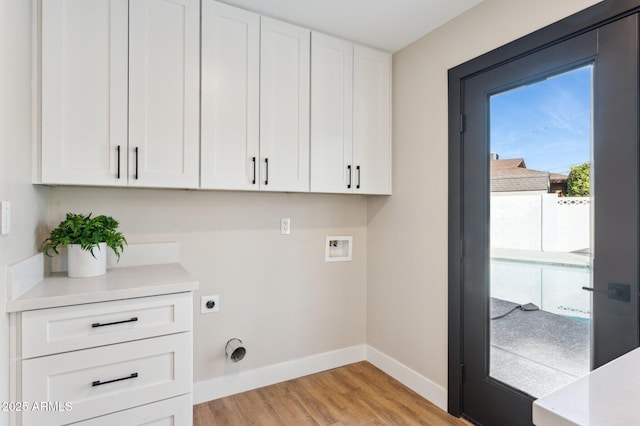 washroom with electric dryer hookup, light wood-type flooring, hookup for a washing machine, and cabinets