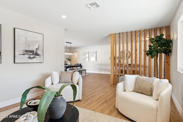 living room featuring light hardwood / wood-style floors and a chandelier