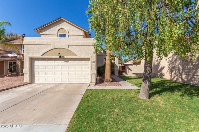 view of front of house with a front lawn, driveway, an attached garage, and stucco siding