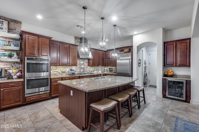 20125 E Via Del Rancho, Queen Creek, AZ 85142 - kitchen featuring wine cooler, a sink, a breakfast bar area, stainless steel appliances, and visible vents