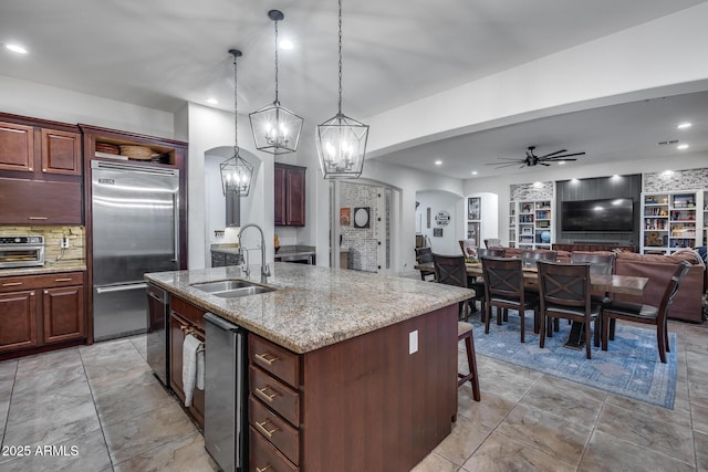 20125 E Via Del Rancho, Queen Creek, AZ 85142 - kitchen with a sink, tasteful backsplash, appliances with stainless steel finishes, a kitchen island with sink, and arched walkways