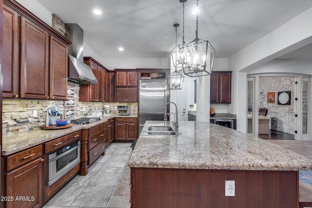 20125 E Via Del Rancho, Queen Creek, AZ 85142 - kitchen featuring stainless steel appliances, decorative backsplash, a center island with sink, a sink, and wall chimney exhaust hood