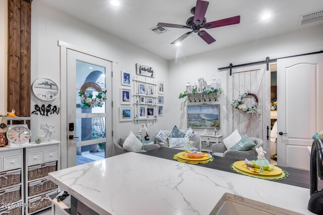 20125 E Via Del Rancho, Queen Creek, AZ 85142 - kitchen featuring a ceiling fan, light stone counters, a barn door, and visible vents