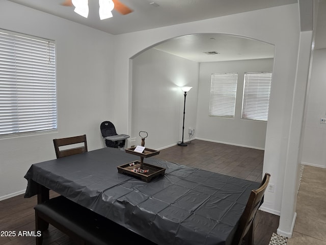 dining room featuring visible vents, arched walkways, ceiling fan, and baseboards