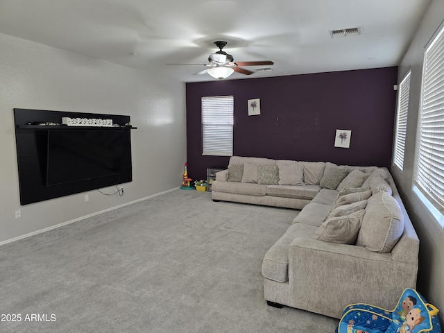 unfurnished living room featuring baseboards, carpet floors, visible vents, and a ceiling fan