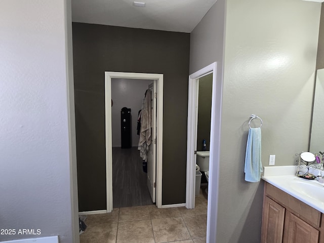 bathroom with toilet, vanity, and tile patterned floors