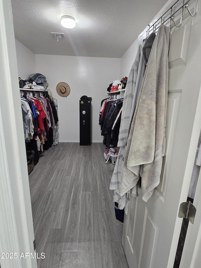 walk in closet featuring visible vents and wood finished floors