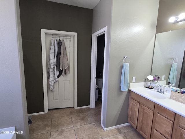 full bath with tile patterned flooring, toilet, vanity, and baseboards