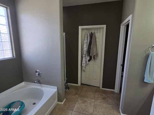 full bathroom featuring tile patterned floors, baseboards, and a bath