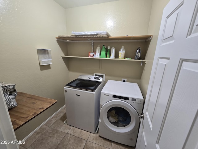 clothes washing area with washer and dryer, laundry area, baseboards, and light tile patterned floors