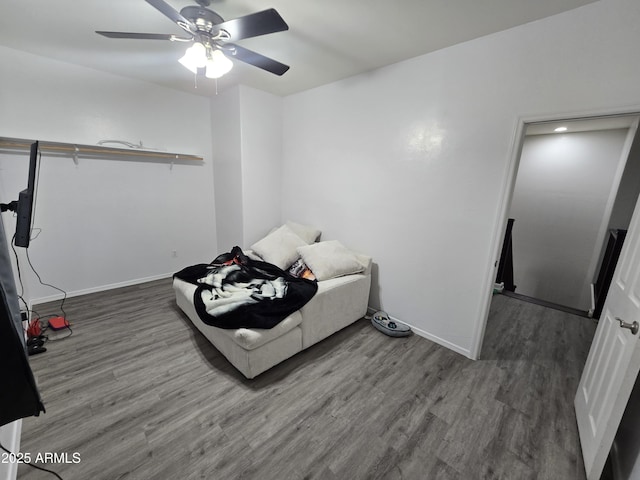 bedroom featuring a ceiling fan, baseboards, and wood finished floors