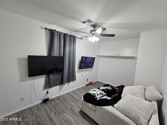 living room featuring visible vents, wood finished floors, a ceiling fan, and baseboards