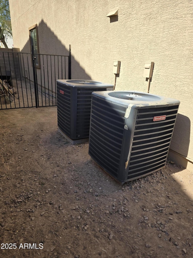 details with fence, cooling unit, and stucco siding