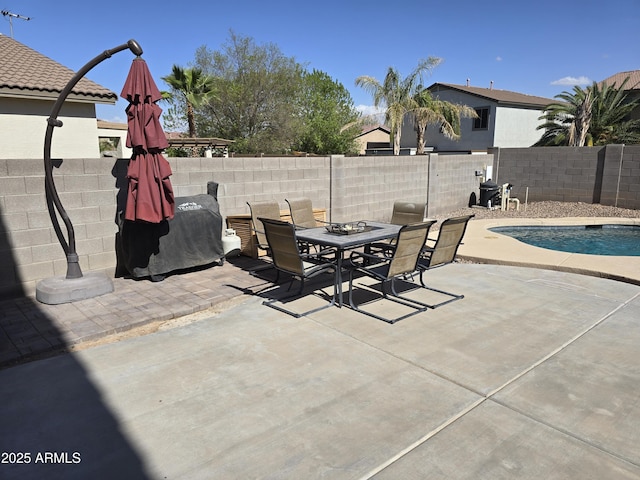 view of patio / terrace with a fenced in pool, outdoor dining space, and a fenced backyard