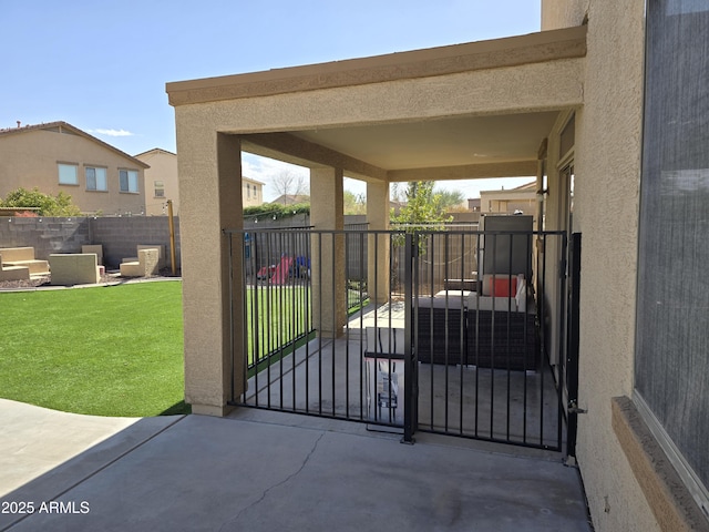 view of gate featuring a fenced backyard and a yard