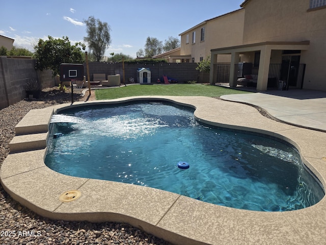 view of pool with a yard, a patio area, and a fenced backyard