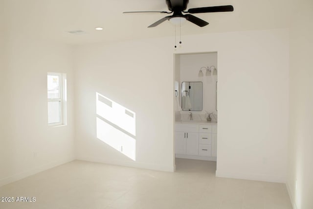 interior space with recessed lighting, baseboards, a sink, and ensuite bathroom