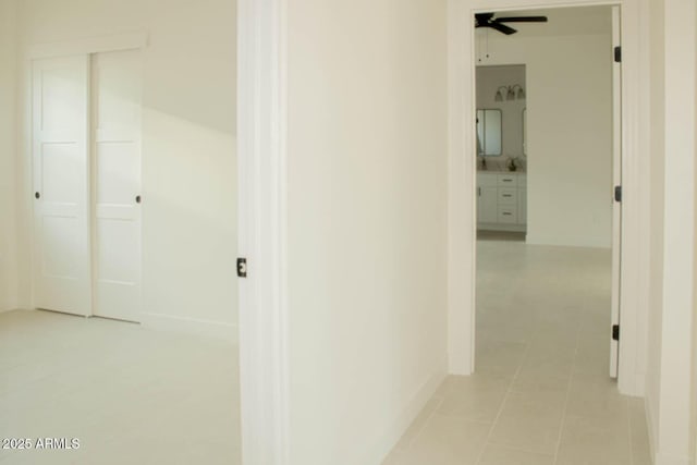 hall with baseboards and light tile patterned floors