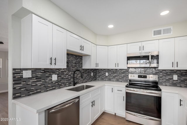 kitchen featuring visible vents, stainless steel appliances, a sink, and light countertops