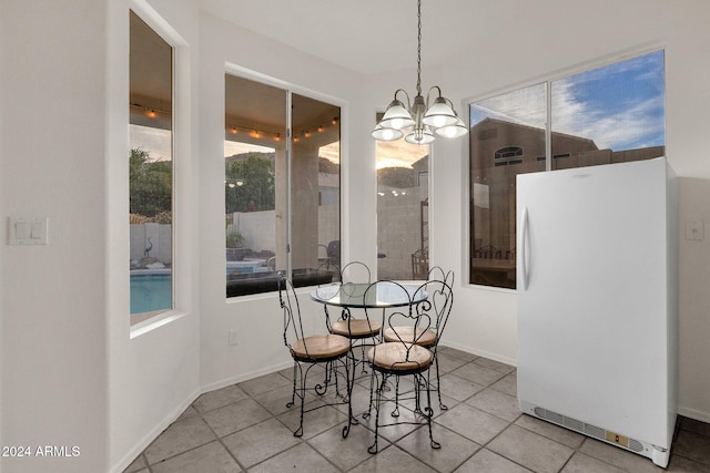 tiled dining area featuring an inviting chandelier