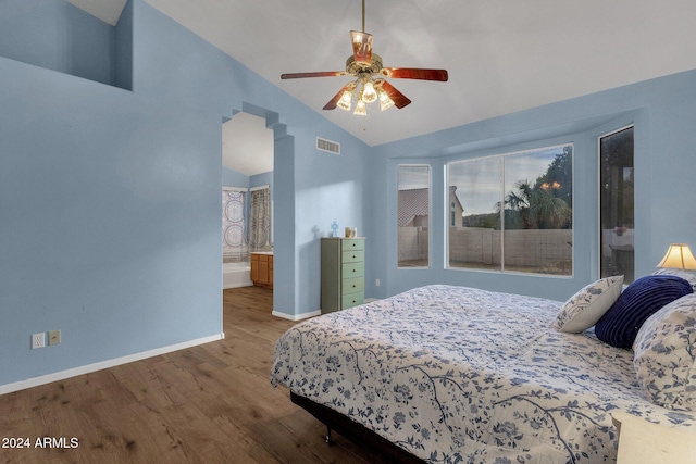 bedroom featuring hardwood / wood-style flooring, ceiling fan, ensuite bath, and vaulted ceiling