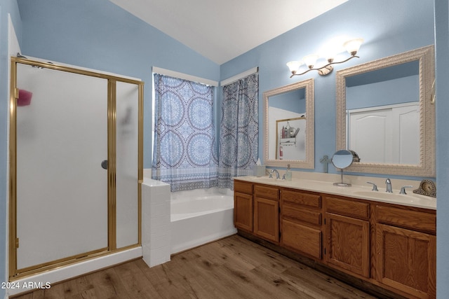 bathroom with hardwood / wood-style flooring, vanity, separate shower and tub, and vaulted ceiling