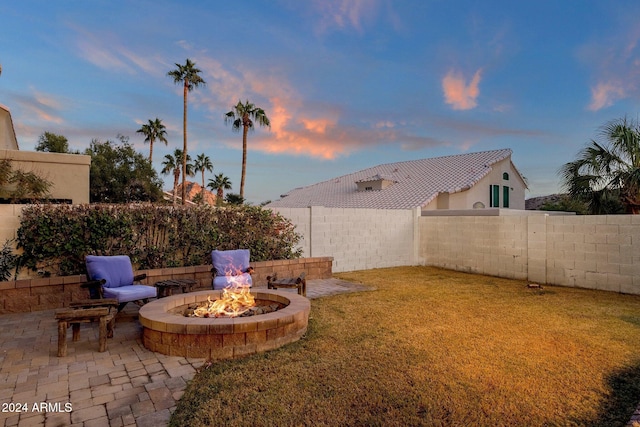 yard at dusk with a patio area and a fire pit