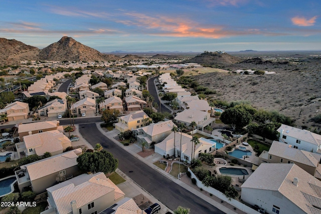 aerial view at dusk featuring a mountain view