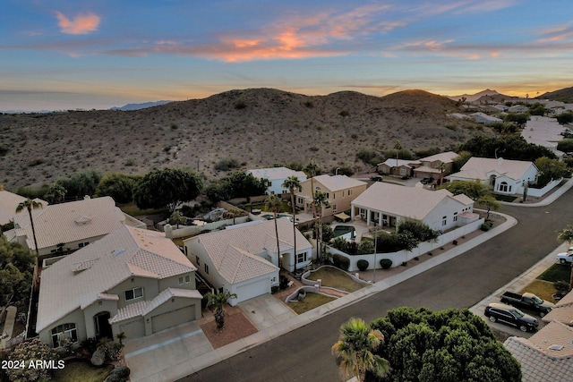 aerial view at dusk featuring a mountain view