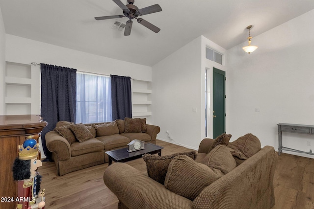 living room with ceiling fan, light hardwood / wood-style floors, lofted ceiling, and built in shelves