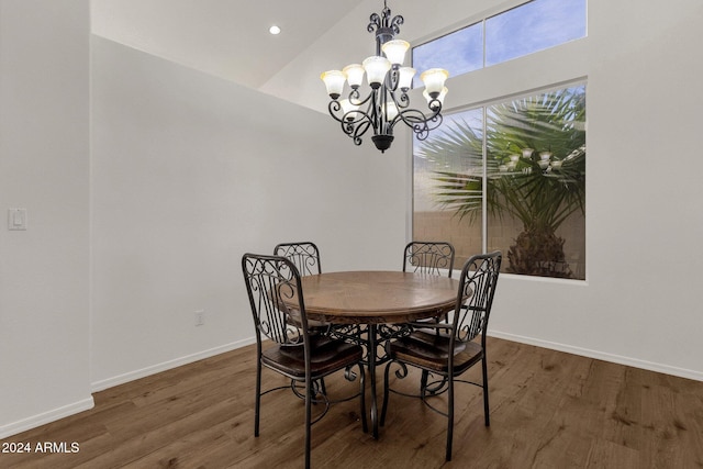 dining space with high vaulted ceiling, dark hardwood / wood-style floors, and a notable chandelier