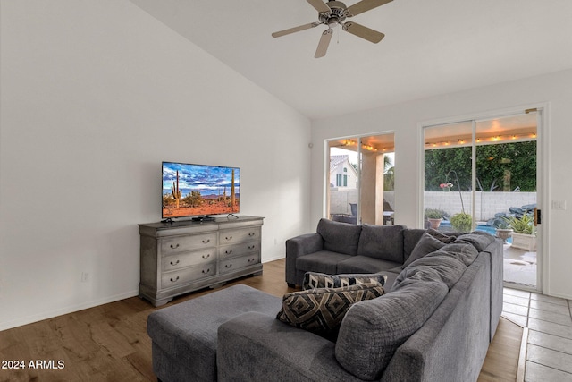 living room with hardwood / wood-style flooring, ceiling fan, and high vaulted ceiling