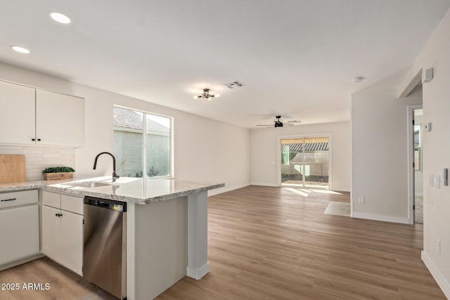 kitchen with dishwasher, kitchen peninsula, ceiling fan, decorative backsplash, and white cabinetry