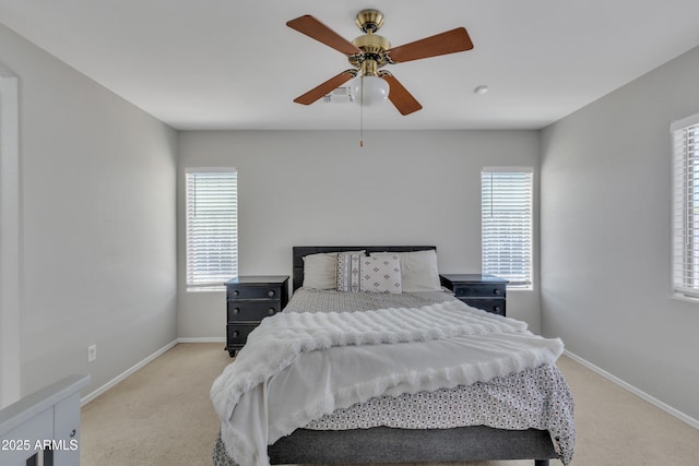 bedroom with baseboards, light colored carpet, and multiple windows