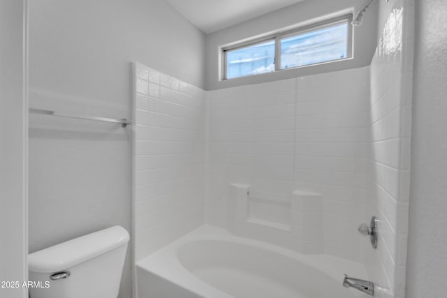 bathroom featuring bathtub / shower combination and toilet