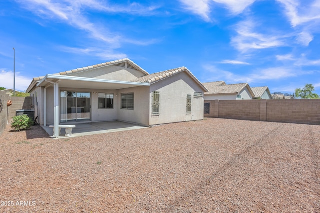 back of property with a patio area, a tiled roof, a fenced backyard, and stucco siding