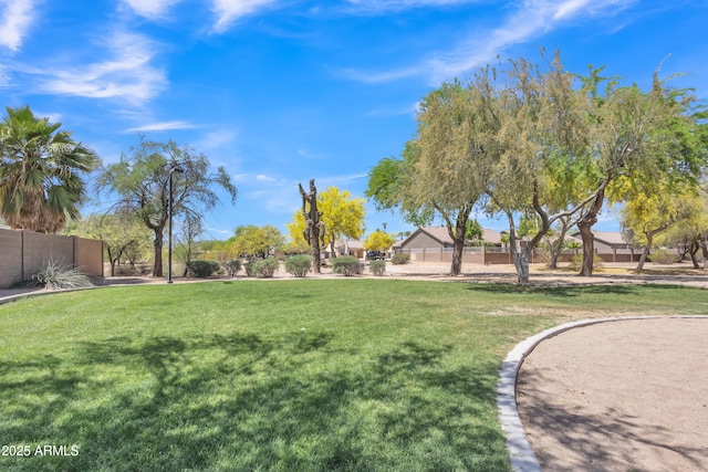 view of property's community featuring a yard and fence