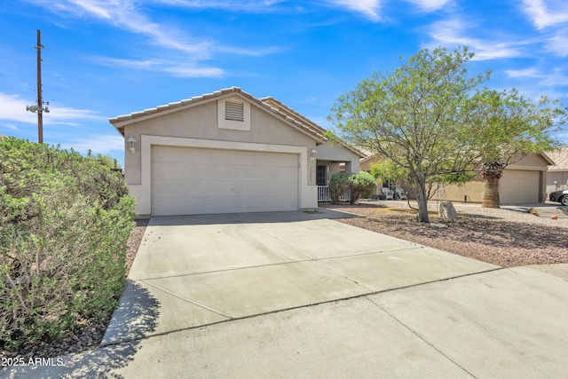 single story home featuring a garage, a tiled roof, concrete driveway, and stucco siding