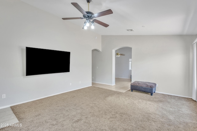 unfurnished living room with baseboards, a ceiling fan, visible vents, arched walkways, and light colored carpet
